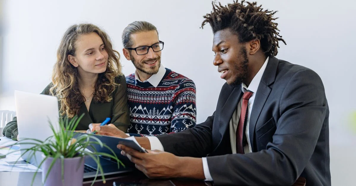 Un groupe diversifié de professionnels collaborant lors d'une réunion de bureau, mettant en avant le travail d'équipe et le partenariat.