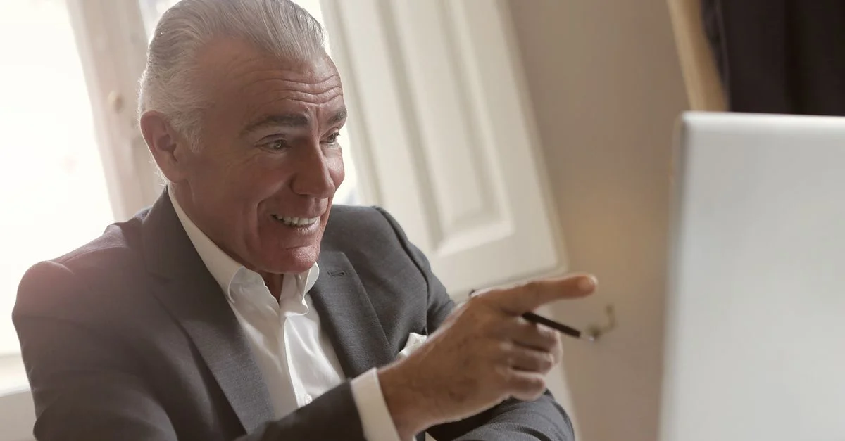 Homme d'affaires mature en costume de bureau participant activement à une réunion numérique.
