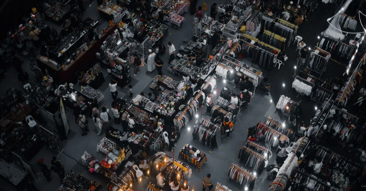 Prise de vue aérienne dynamique d'un marché intérieur vibrant à Kuala Lumpur, Malaisie, mettant en valeur des stands divers et une activité foisonnante.