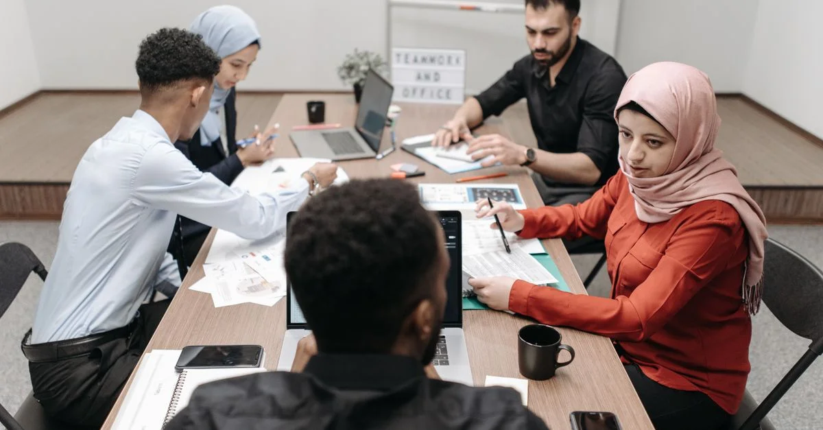 Une équipe diversifiée de collègues engagée dans une réunion productive à une table de conférence moderne.