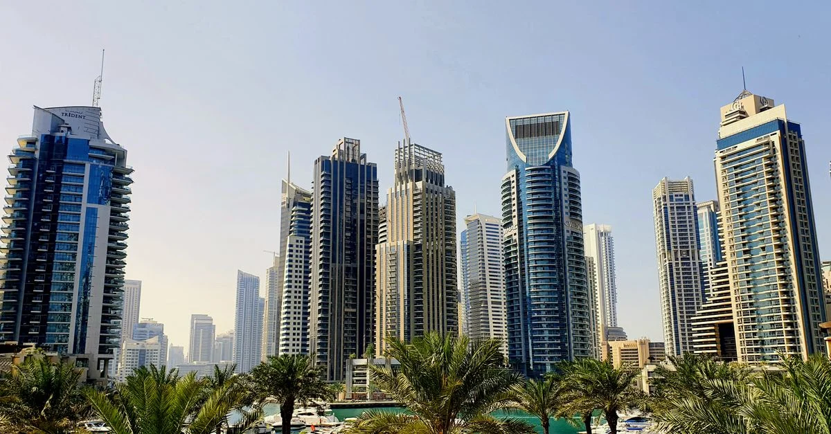 Une vue dynamique de la ligne d'horizon de Dubaï avec ses gratte-ciel modernes et des palmiers pendant la journée.