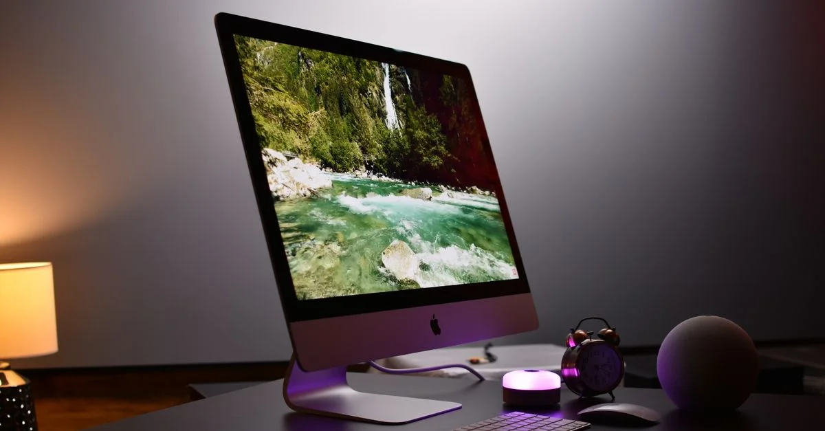 Espace de travail intérieur élégant avec un configuration d'ordinateur de bureau moderne et des accessoires, idéal pour la productivité.